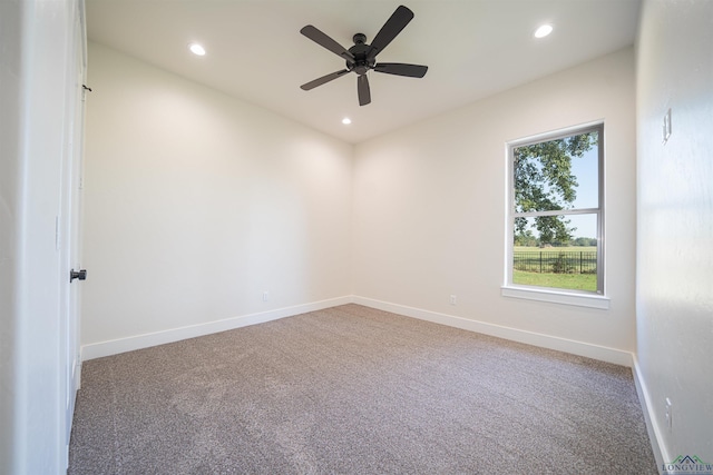 carpeted spare room featuring ceiling fan