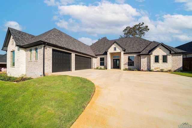 french country home with a front lawn and a garage