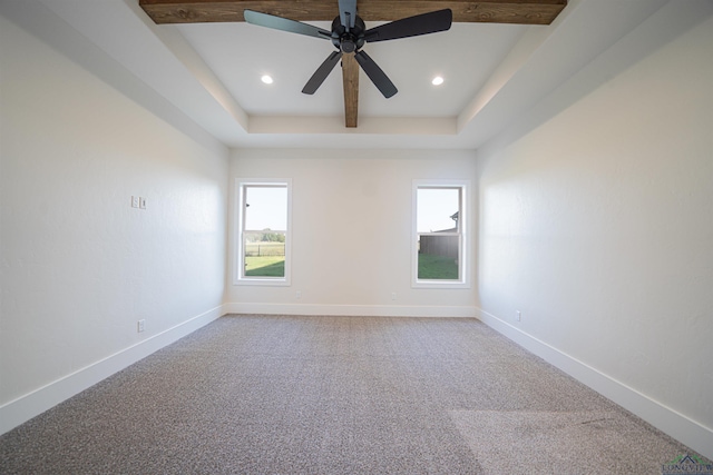 spare room with carpet floors, a raised ceiling, and ceiling fan