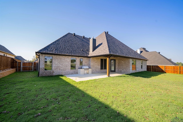 rear view of property featuring a lawn, area for grilling, and a patio area