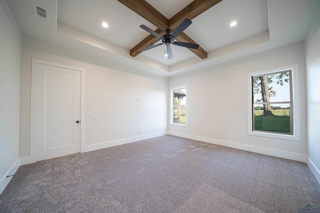 carpeted spare room with ceiling fan, beam ceiling, and a raised ceiling