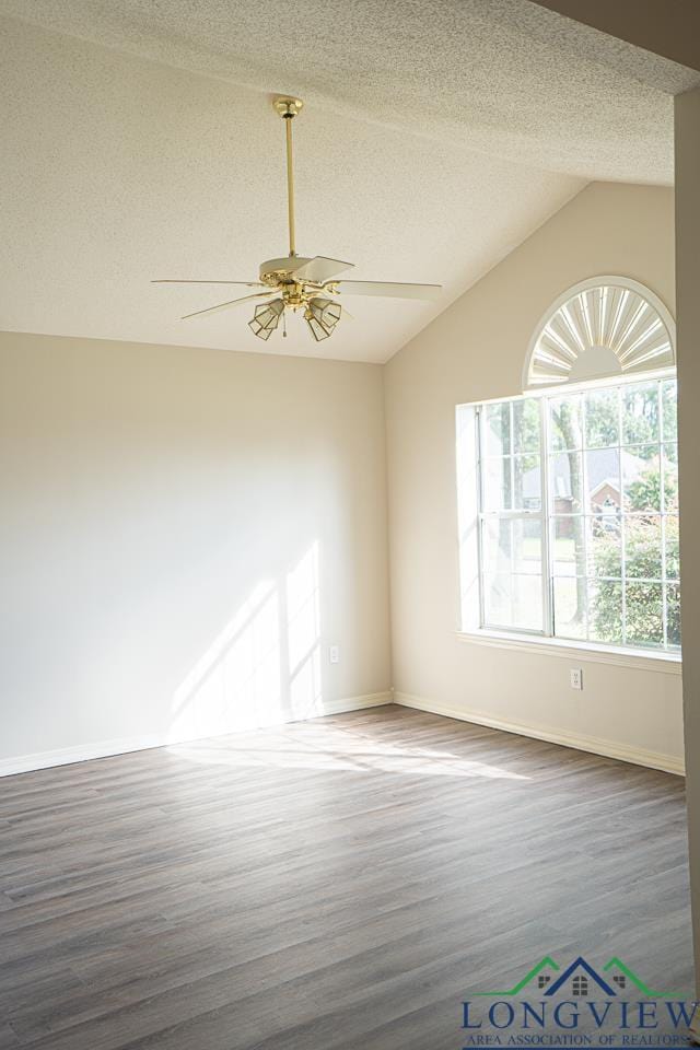 spare room with ceiling fan, a textured ceiling, and vaulted ceiling