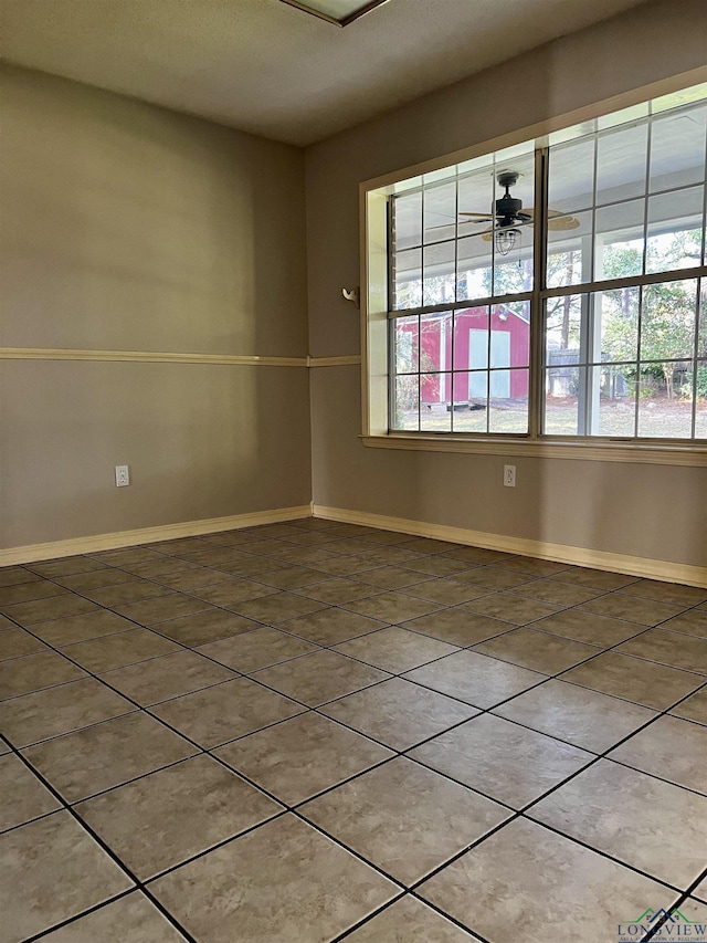 tiled spare room featuring ceiling fan