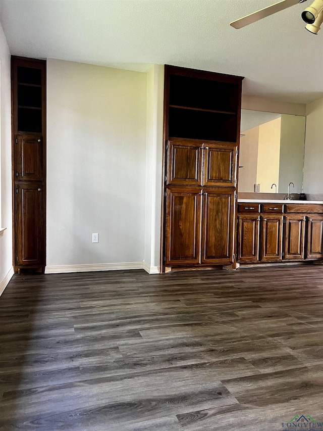 interior space with ceiling fan, sink, and dark wood-type flooring