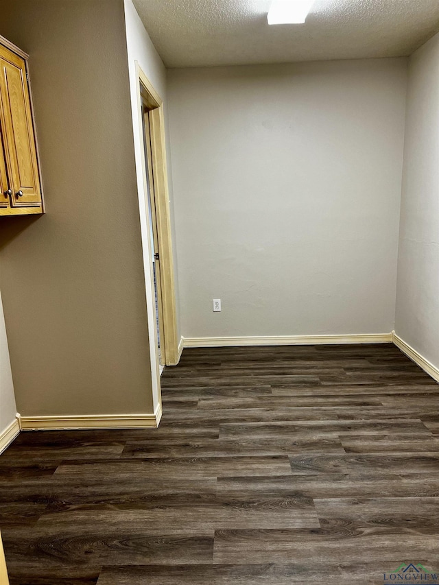 unfurnished room featuring a textured ceiling and dark wood-type flooring