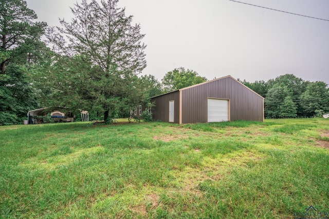 view of yard with a garage, a carport, and an outdoor structure