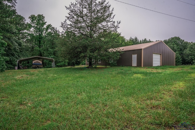 view of yard featuring a carport, a garage, and an outdoor structure