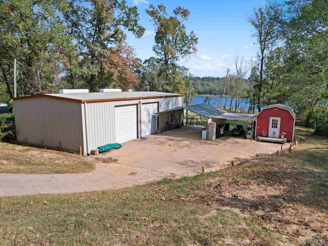 view of outbuilding with a water view, a garage, and a carport