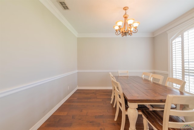 dining space with crown molding, dark wood-type flooring, and an inviting chandelier