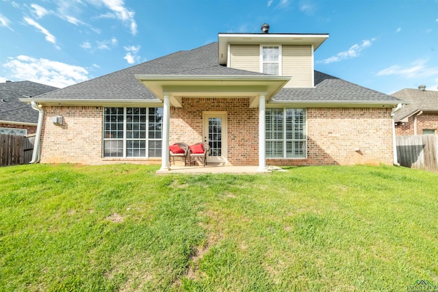 rear view of property featuring a yard and a patio