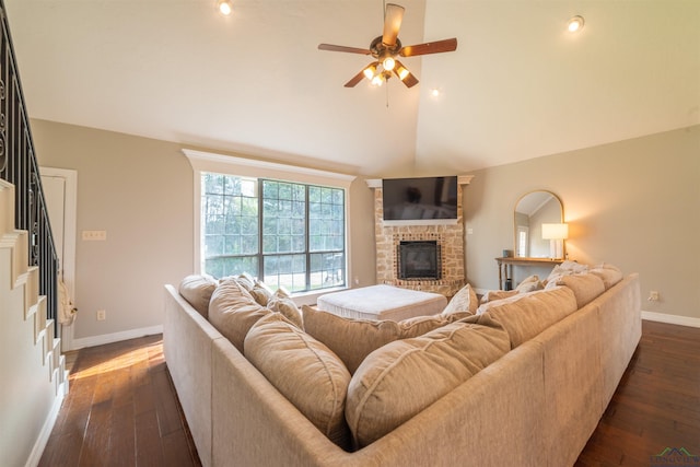 living room with ceiling fan, dark hardwood / wood-style flooring, a fireplace, and vaulted ceiling