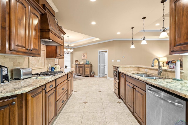 kitchen featuring decorative light fixtures, stainless steel appliances, light stone counters, and sink