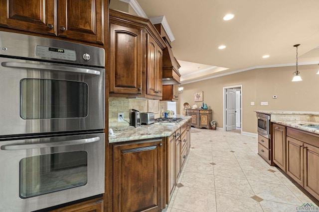 kitchen with light stone countertops, appliances with stainless steel finishes, crown molding, light tile patterned floors, and decorative light fixtures