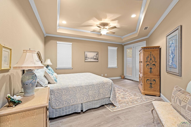 bedroom with ceiling fan, a raised ceiling, and ornamental molding