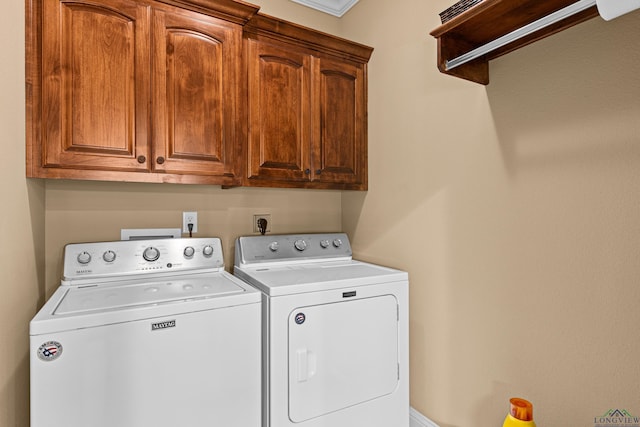 clothes washing area featuring cabinets and washing machine and clothes dryer