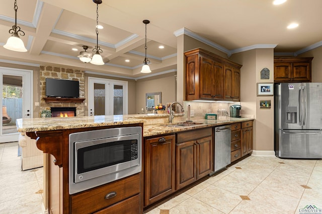 kitchen featuring appliances with stainless steel finishes, decorative light fixtures, coffered ceiling, and sink