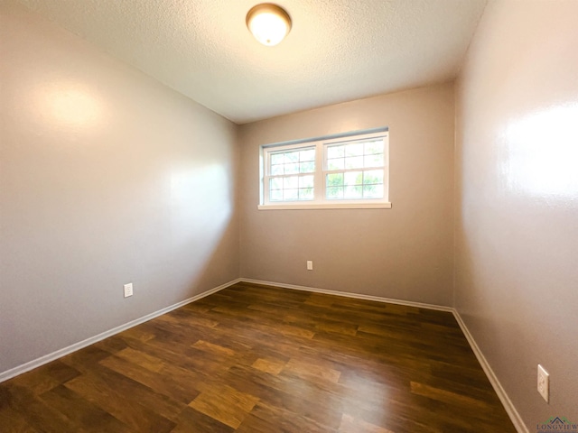 spare room with dark hardwood / wood-style flooring and a textured ceiling