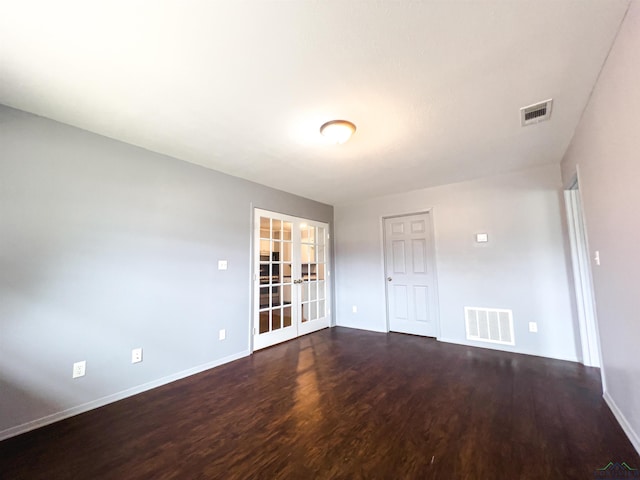 spare room with french doors and dark hardwood / wood-style floors