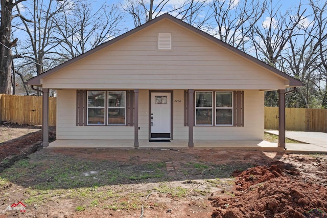 bungalow-style home featuring covered porch and fence