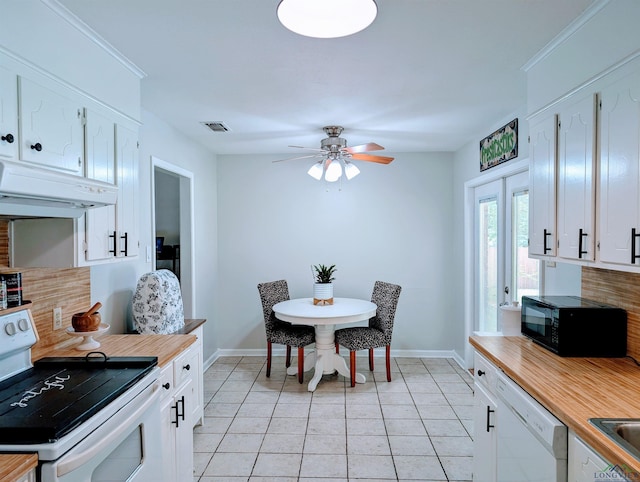 kitchen with baseboards, tasteful backsplash, under cabinet range hood, and white appliances