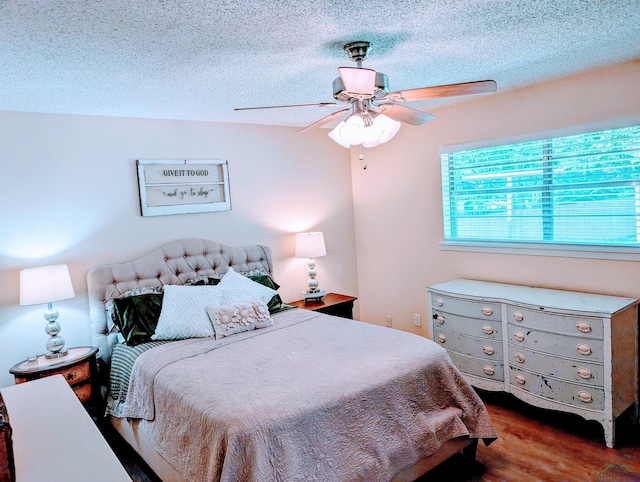bedroom with a textured ceiling, ceiling fan, and wood finished floors