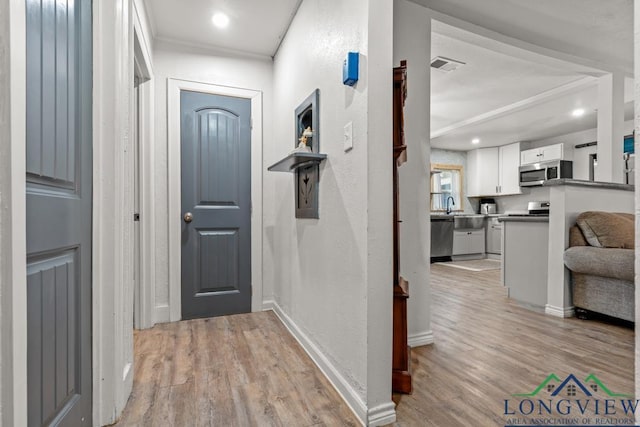 718 Pine St, Gilmer, TX 75644 - foyer featuring light wood-type flooring, baseboards, visible vents, and a textured wall