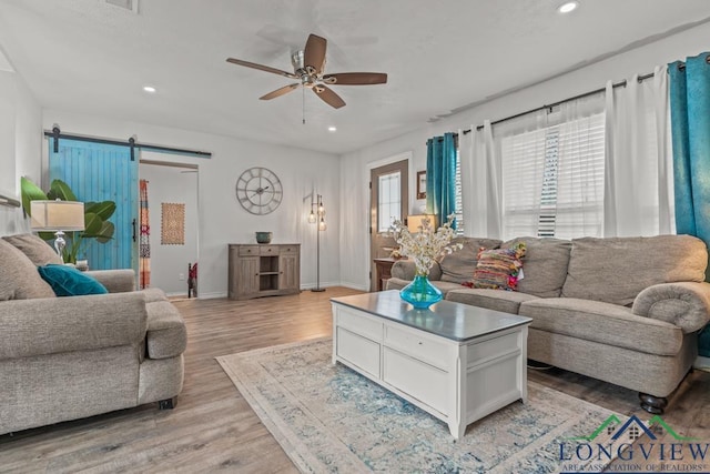 718 Pine St, Gilmer, TX 75644 - living room with light wood-style flooring, a barn door, a ceiling fan, and recessed lighting