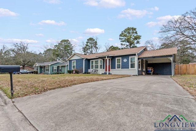 718 Pine St, Gilmer, TX 75644 - ranch-style house featuring fence, a carport, a shingled roof, a front lawn, and driveway