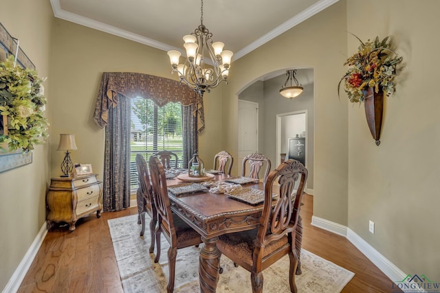 220 Cedar Rdg, Longview, TX 75602 - dining area with crown molding, arched walkways, wood finished floors, and a chandelier