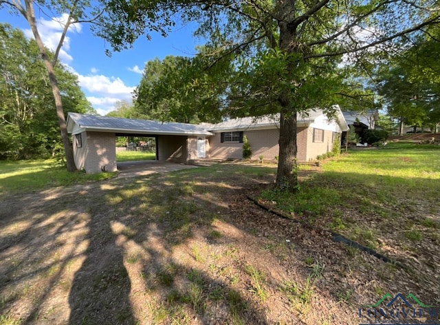 3401 Cooper Ln, Texarkana, TX 75503 - back of house featuring a carport, a yard, and brick siding