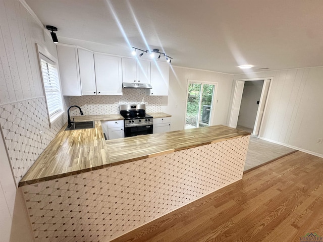 3401 Cooper Ln, Texarkana, TX 75503 - kitchen featuring stainless steel range with electric cooktop, a sink, under cabinet range hood, light wood-style flooring, and white cabinets