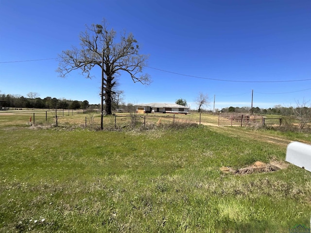 view of yard with a rural view and fence