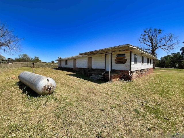 view of side of home featuring fence and a yard
