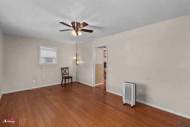 empty room featuring radiator, ceiling fan, dark hardwood / wood-style flooring, cooling unit, and a textured ceiling