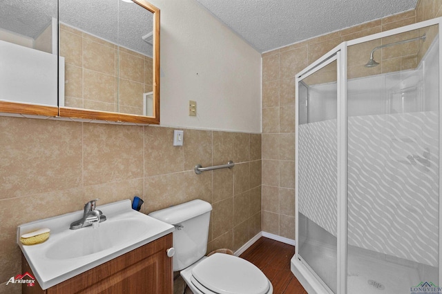 bathroom with walk in shower, vanity, a textured ceiling, and toilet