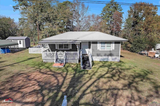 view of front facade with a front yard, a shed, and a wooden deck