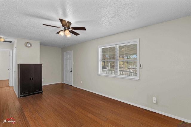 empty room with wood-type flooring, a textured ceiling, and ceiling fan