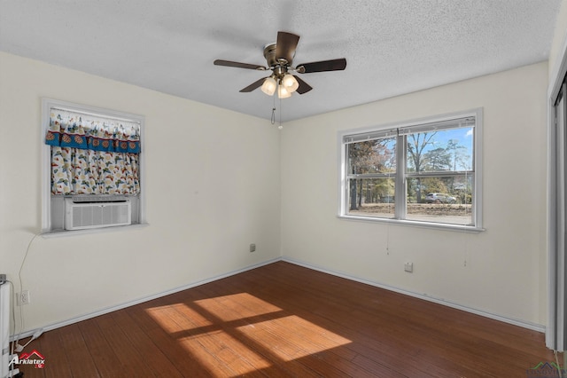 empty room with hardwood / wood-style floors, ceiling fan, cooling unit, and a textured ceiling