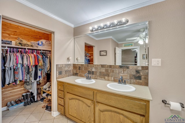 bathroom with ceiling fan, tasteful backsplash, tile patterned floors, crown molding, and vanity