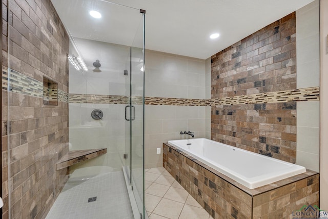 bathroom with tile patterned floors, shower with separate bathtub, and tile walls