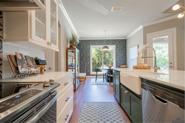 kitchen with sink, dark wood-type flooring, light stone counters, decorative light fixtures, and appliances with stainless steel finishes