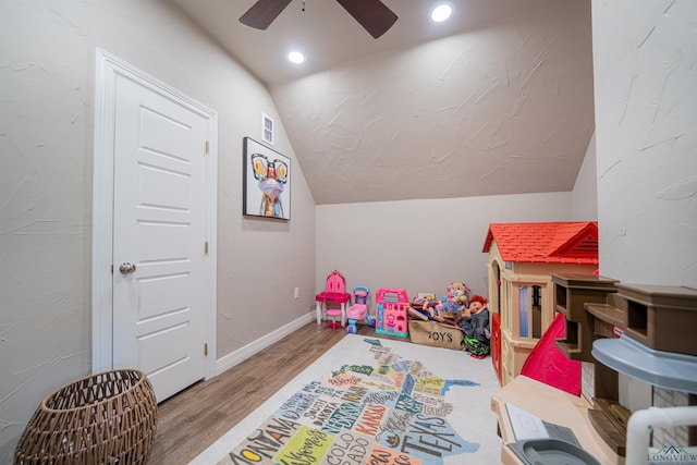 game room with hardwood / wood-style floors, ceiling fan, and vaulted ceiling