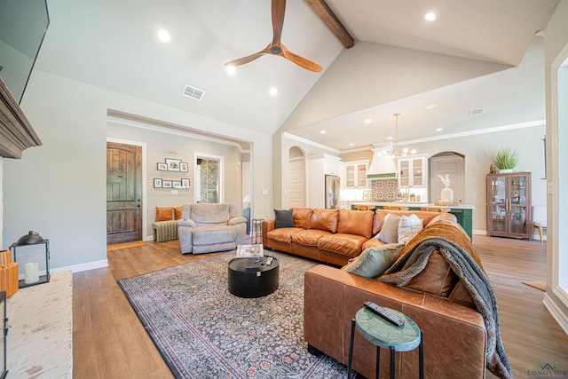 living room featuring radiator, ceiling fan with notable chandelier, beam ceiling, high vaulted ceiling, and hardwood / wood-style floors