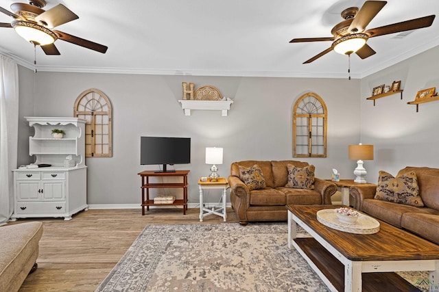 living room featuring ceiling fan, ornamental molding, and light hardwood / wood-style flooring