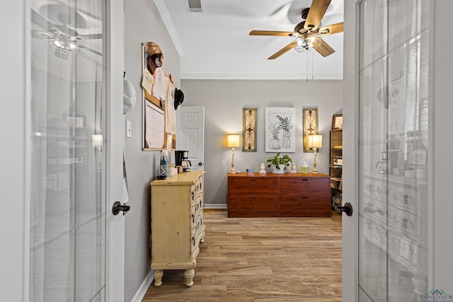 foyer entrance featuring ornamental molding, ceiling fan, and light wood-type flooring