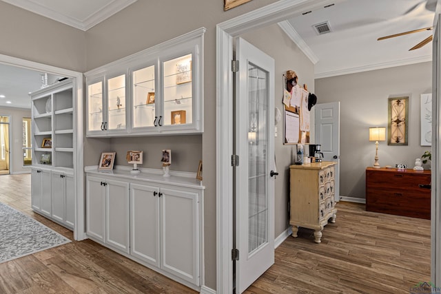 hallway featuring hardwood / wood-style floors and crown molding