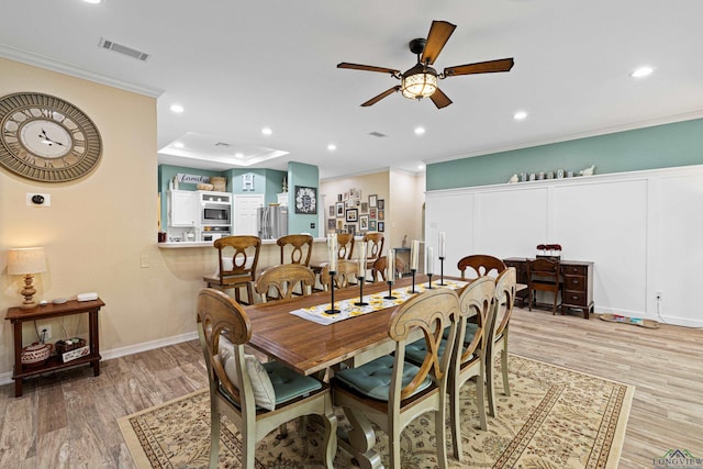 dining room featuring light wood-type flooring, ceiling fan, and crown molding