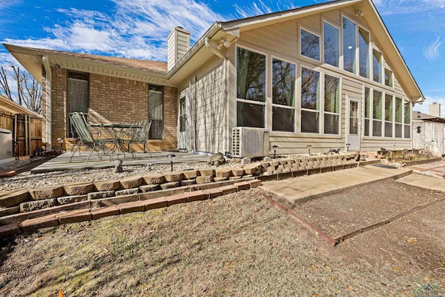 rear view of house with ac unit, a sunroom, and a patio