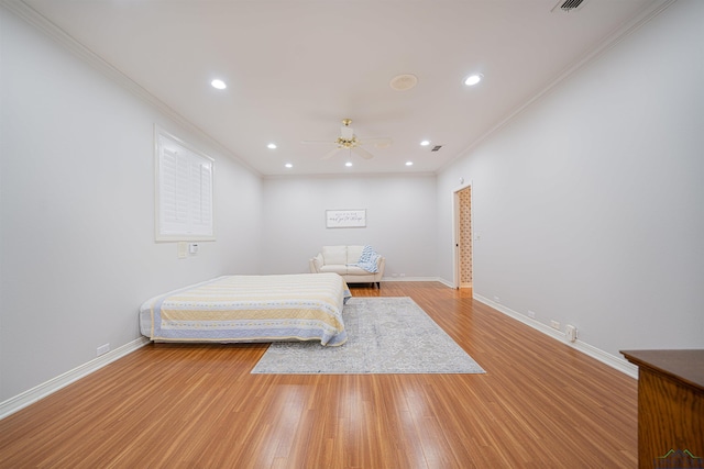 bedroom with light hardwood / wood-style floors, ceiling fan, and ornamental molding