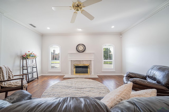 living room featuring a high end fireplace, dark hardwood / wood-style floors, a healthy amount of sunlight, and ceiling fan